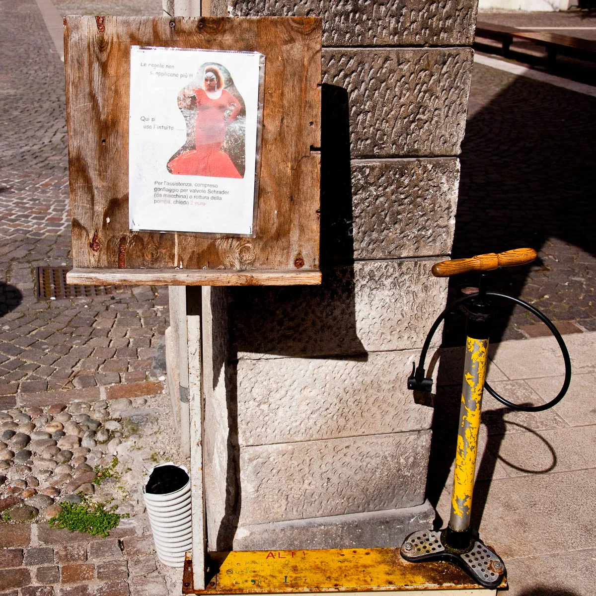 Warning sign and a pump by a bicycle shop, Vicenza, Veneto, Italy