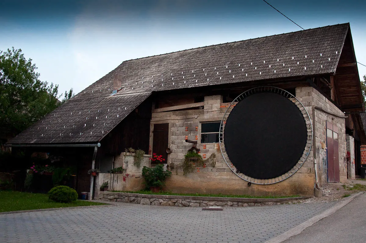 Kozolec - Traditional wooden hayrack barn with a huge trampoline leaning on it, Primostek, Slovenia - www.rossiwrites.com