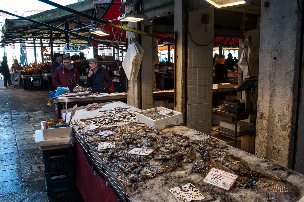 Customers looking at a fishmonger's stall - Rialto Fish Market, Venice, Italy - www.rossiwrites.com