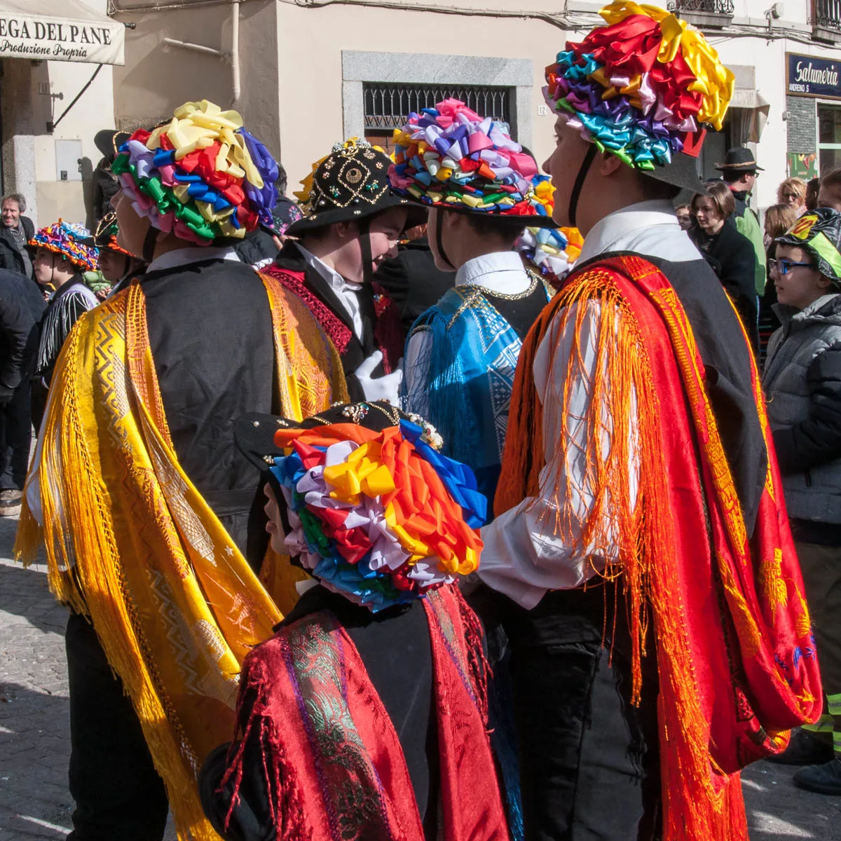 Men and kids in traditional dress with long colourful scarves - Bagolino, Lombardy, Italy - www.rossiwrites.com