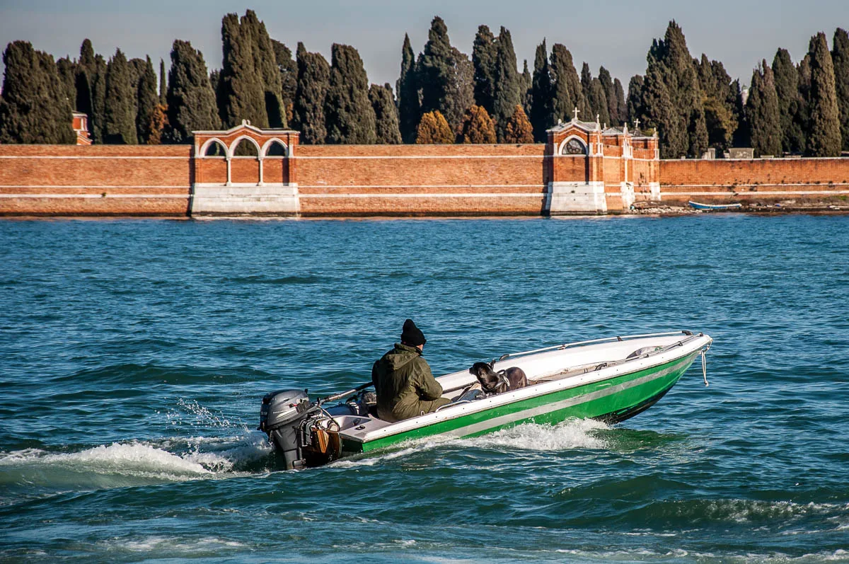 A man and his dog in a boat in the Venetian lagoon - Venice, Veneto, Italy - www.rossiwrites.com