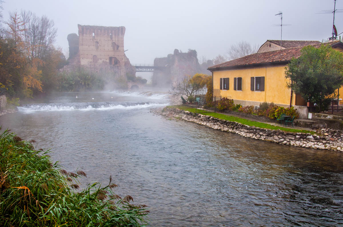 The Visconti bridge with the river Mincio and a yellow house - Borghetto sul Mincio, Veneto, Italy - rossiwrites.com