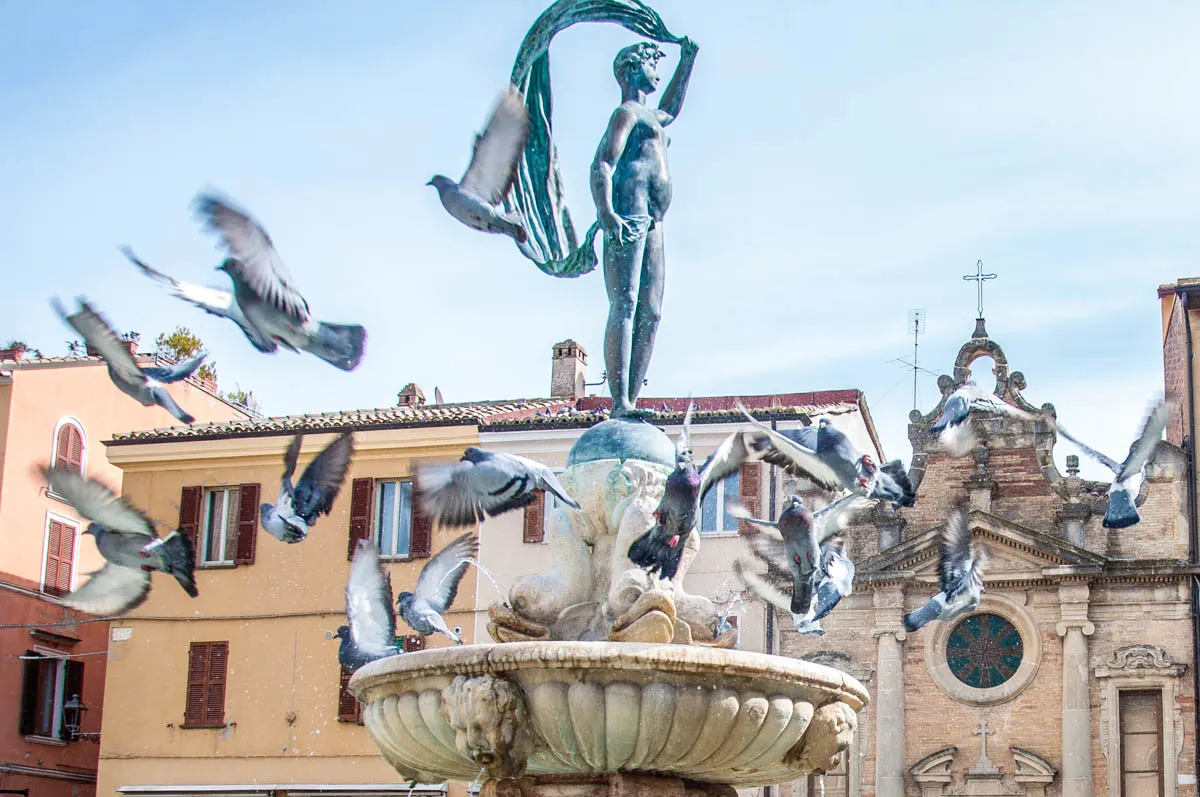 Pigeons flying off a fountain - Fano, Marche, Italy - www.rossiwrites.com