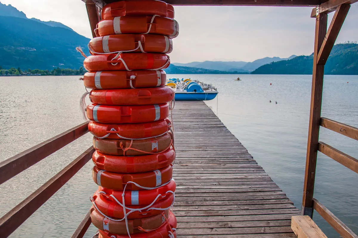A view of Lake Caldonazzo with safety throw rings and pedalos in the early evening - Trentino, Italy - rossiwrites.com