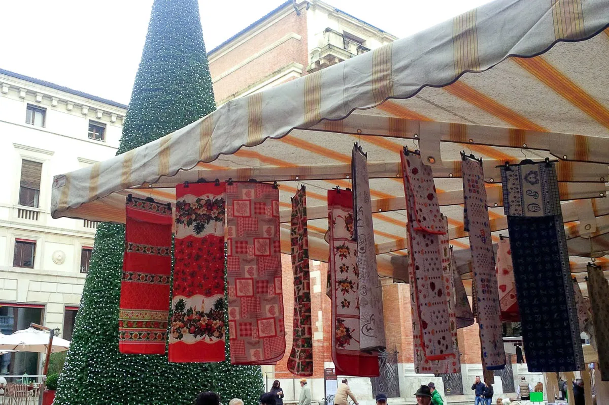 Market stall selling tableclothes with Christmas patterns- Vicenza, Italy - rossiwrites.com