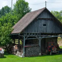 Kozolec - Wooden hayrack barn with a red tractor, Bela Krajina, Slovenia - www.rossiwrites.com