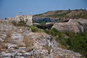Remnants from medieval buildings on the plateau with the wooden bridge at the back, Ovech Fortress, Provadia, Bulgaria - www.rossiwrites.com