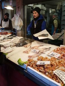A fishmonger selling fish - Rialto Fish Market, Venice, Italy - rossiwrites.com
