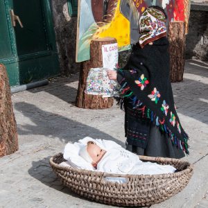 The baby doll and a girl in a traditional folk dress - Bagolino, Lombardy, Italy - www.rossiwrites.com