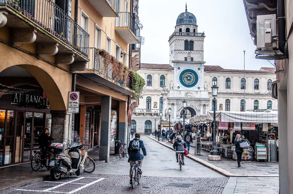 Cyclists heading for the daily market on Piazza dei Signori - Padua, Italy - rossiwrites.com