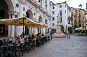 People having coffee in the shadow of the Palladio's Basilica and Palladio's statue - Vicenza, Veneto, Italy - rossiwrites.com