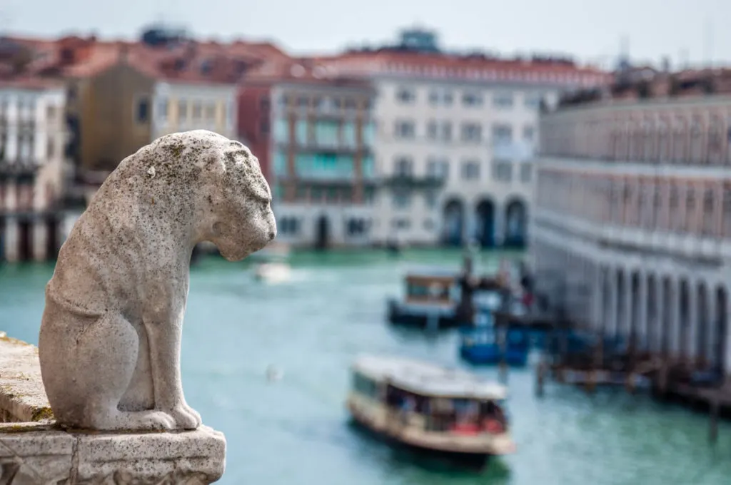 A small stone lion overlooks the Grand Canal in Venice - Veneto, Italy - www.rossiwrites.com