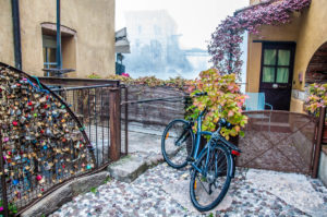 A bike, the old mills and the Visconti Bridge at the back - Borghetto sul Mincio, Italy - www.rossiwrites.com