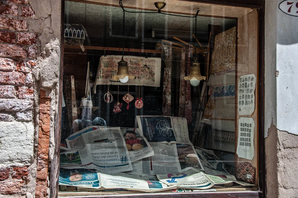 Shop window covered with newspapers - Venice, Italy - rossiwrites.com