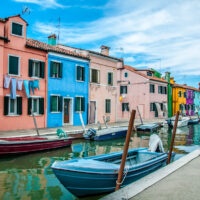Colourful houses and a canal with boats under a blue sky - Burano, Veneto, Italy - rossiwrites.com