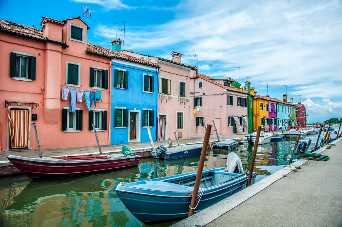 Colourful houses and a canal with boats under a blue sky - Burano, Veneto, Italy - rossiwrites.com
