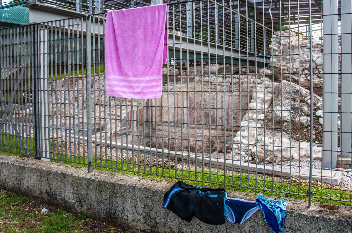 A towel and swimming costumes drying on the fence of the Ancient Roman villa - Bau Beach - Toscolano, Lombardy, Italy - rossiwrites.com