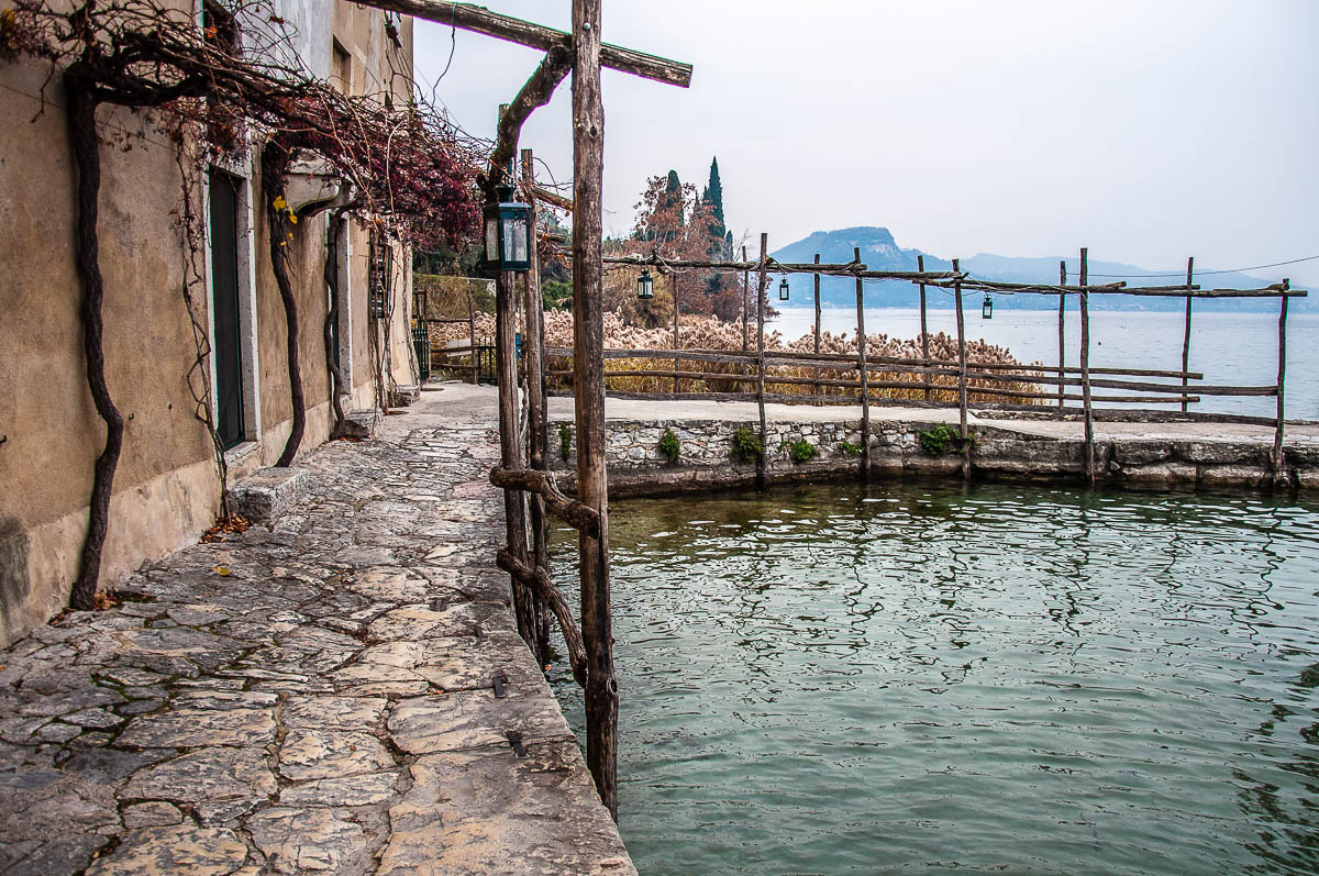 The stone path on the edge of the small harbour - Punta di San Vigilio - Lake Garda, Italy - rossiwrites.com