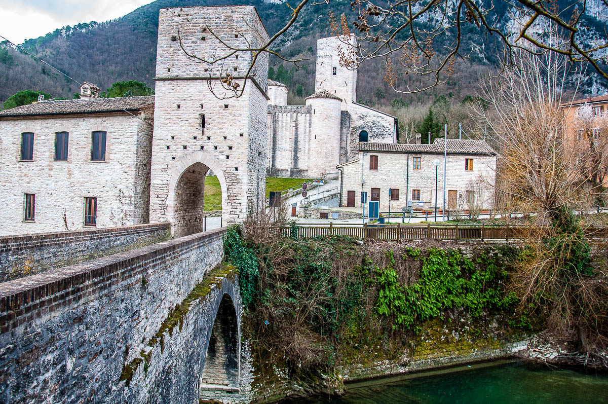 The Roman bridge over the river Sentino with the Abbey of San Vittore delle Chiuse - Marche, Italy - rossiwrites.com