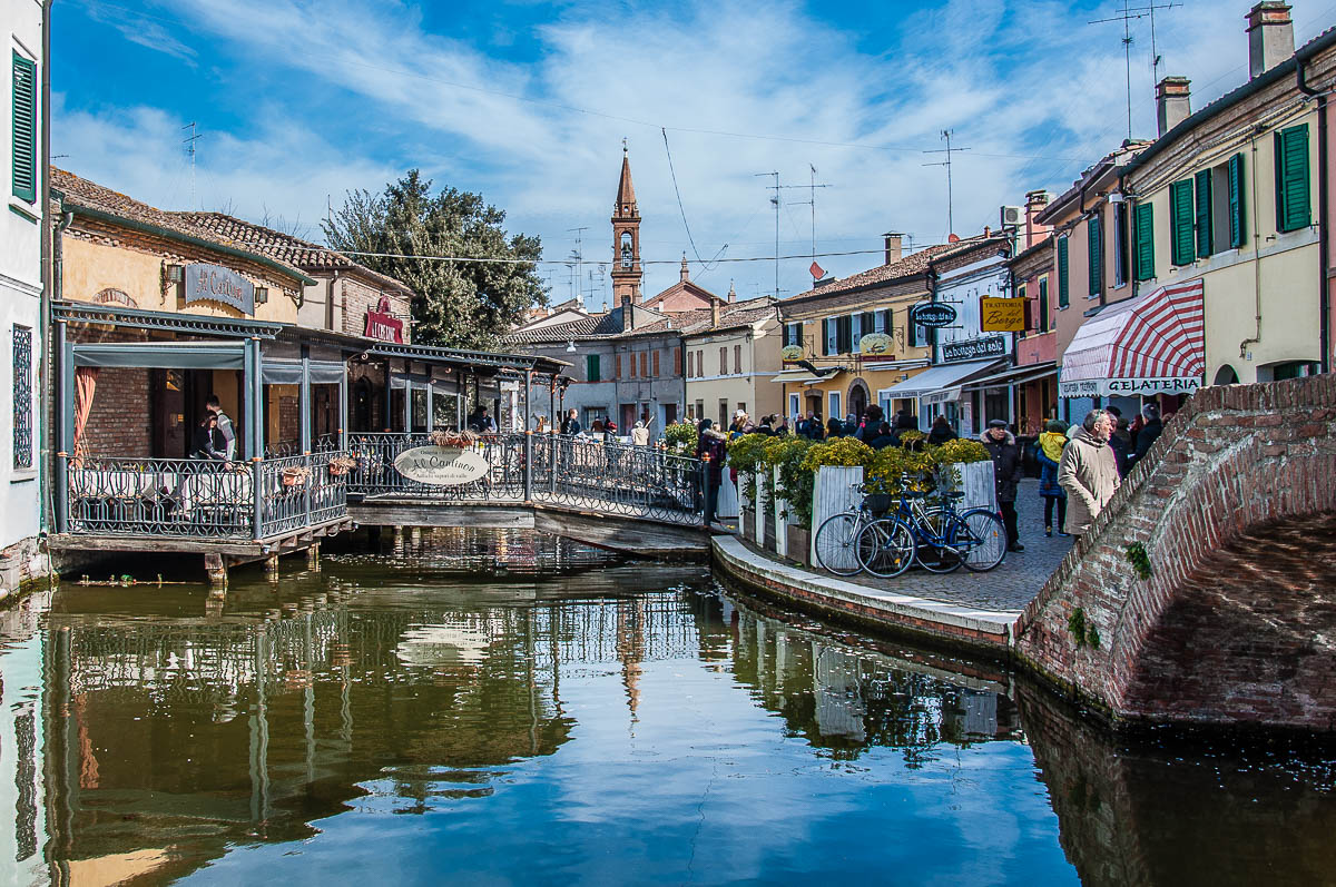 View of the town with restaurants and people - Comacchio, Italy - rossiwrites.com
