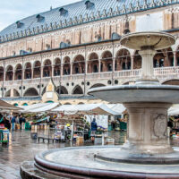 View of the fountain in front of the medieval town hall Palazzo della Ragione in Padua, Italy - rossiwrites.com