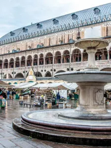 View of the fountain in front of the medieval town hall Palazzo della Ragione in Padua, Italy - rossiwrites.com