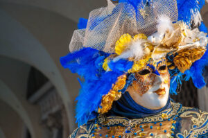 A beautiful mask in blue and gold in front of the Doge's Palace - Venice, Italy - rossiwrites.com