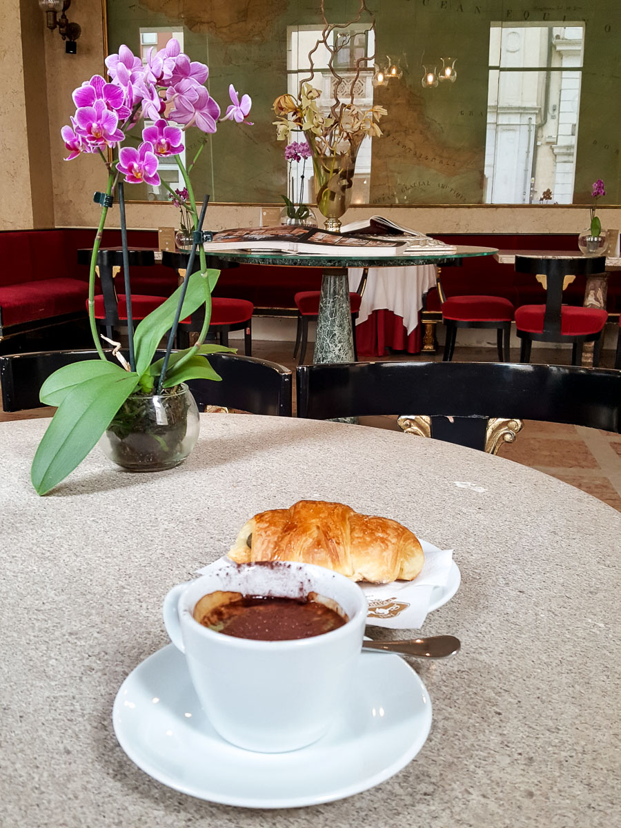 A Pedrocchi coffee served with a pastry on a table decorated with an orchid- Caffe Pedrocchi - Padua, Italy - rossiwrites.com