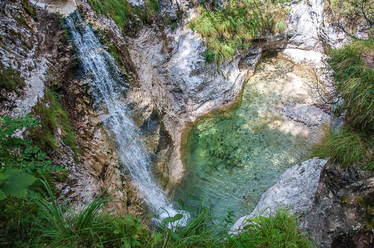 A tall waterfall feeds one of the rockpools of Cadini del Brenton - Dolomites, Italy - rossiwrites.com