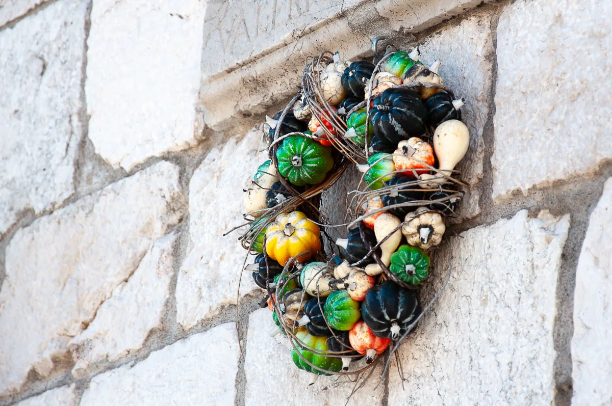 Pumpkin wreath attached to the facade of the Palazzo Comunale - Venzone, Italy - rossiwrites.com