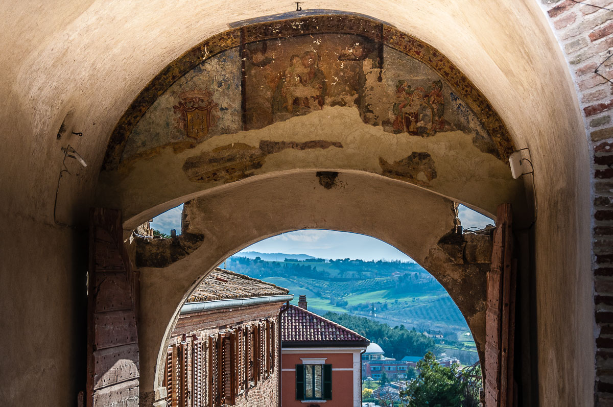 The faded frescoes of the main enrance gate into the fortified village - Gradara, Italy - rossiwrites.com