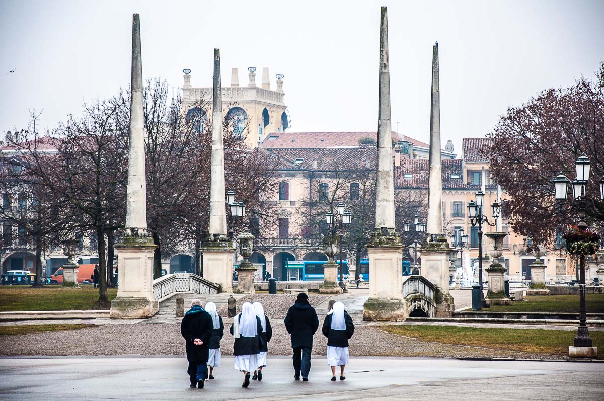 A group of nuns and priests walking towards the bridge with the obelisks on Prato della Valle - Padua, Italy - rossiwrites.com