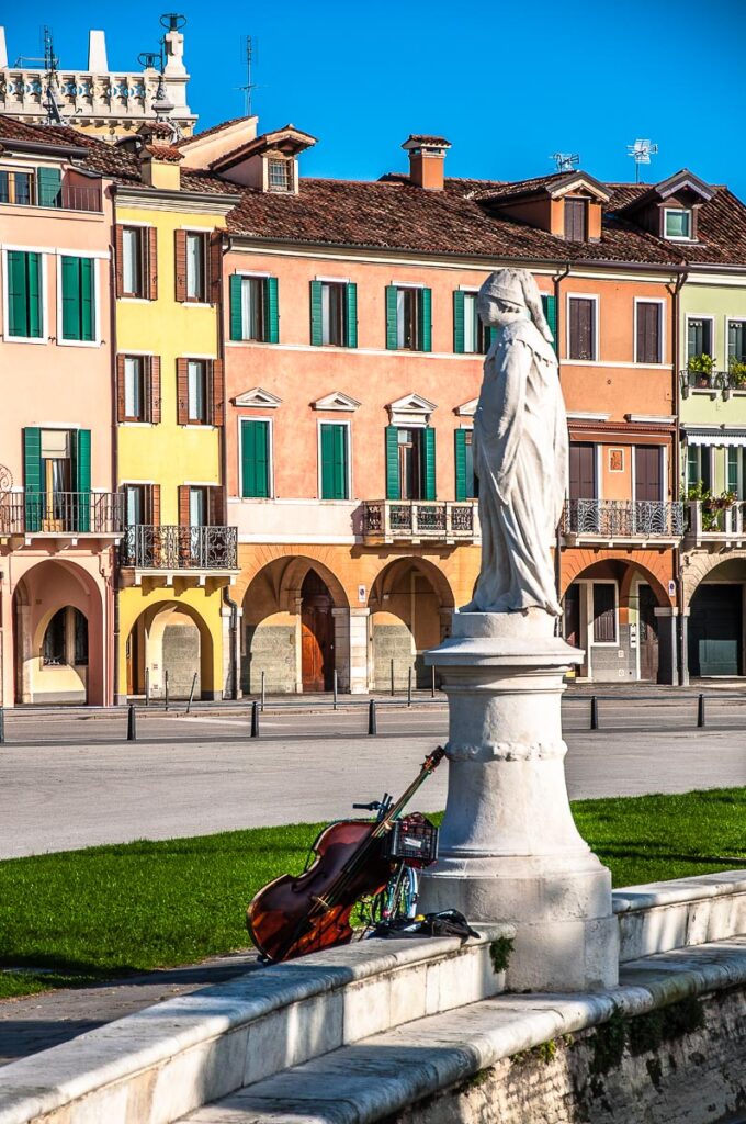 Violoncello by a statue on the elliptical canal of Prato della Valle - Padua, Italy - rossiwrites.com