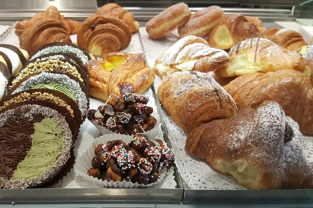A spread with breakfast cakes and pastries in an Italian patisserie - Marche, Italy - rossiwrites.com