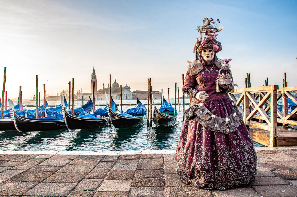 A beautiful mask in purple with a birdcage on her head - Venice, Italy - rossiwrites.com