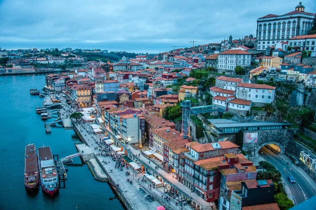 A panorama at dusk of the River Douro and the historic centre from the top of of Dom Luis I Bridge - Porto, Portugal - rossiwrites.com
