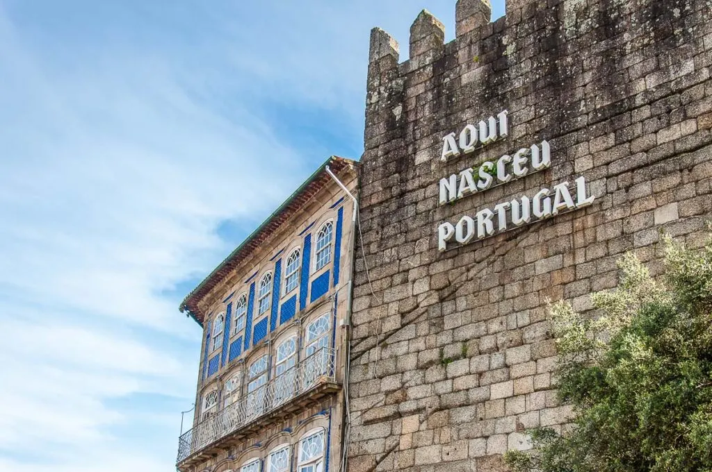 The iconic sign Portugal Was Born Here on the medieval wall - Guimarães, Portugal - rossiwrites.com