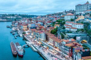 Panoramic view at dusk of the River Douro and the historic centre of Porto seen from the top of of Dom Luis I Bridge - Porto, Portugal - rossiwrites.com