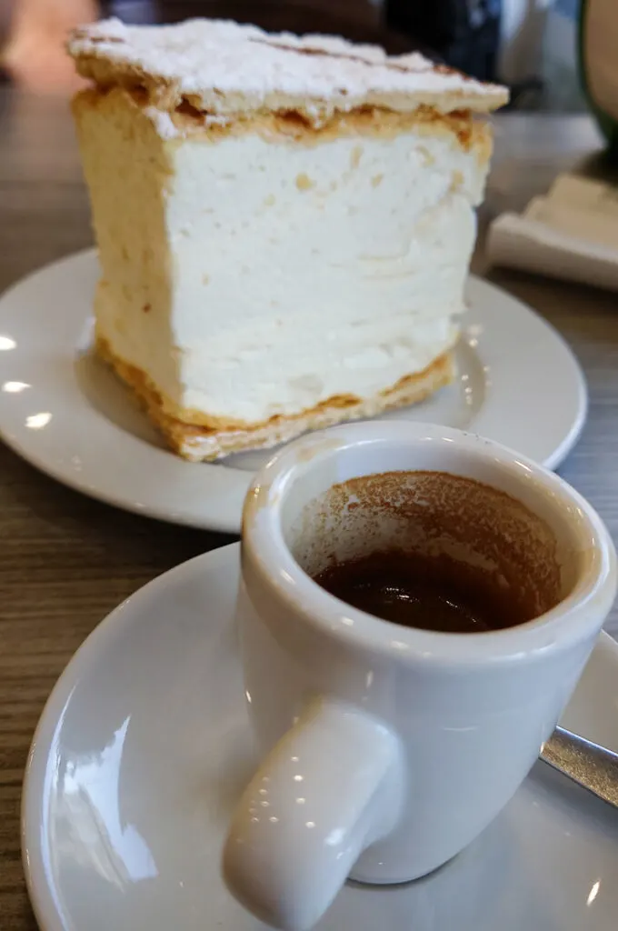 En espresso with a large slice of mil folhas de merengue - Porto, Portugal - rossiwrites.com