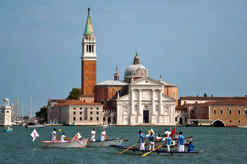 Boats waiting for the start of the Historical Regatta in front of the island of San Giorgio Maggiore - Venice, Italy - rossiwrites.com