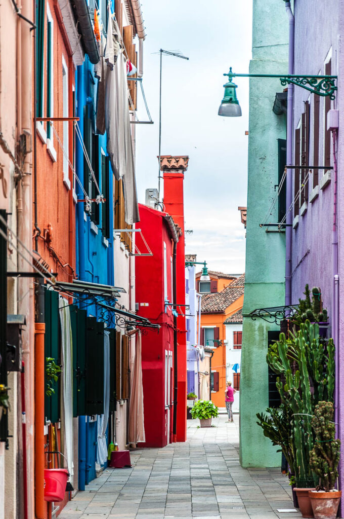 Colourful houses flanking a small courtyard on the island of Burano in Italy - rossiwrites.com