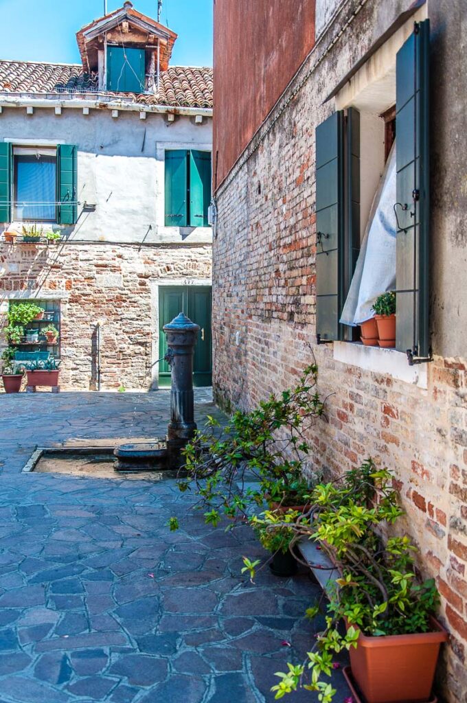 Sunny courtyard with a drinking fountain on the island of Giudecca - Venice, Italy - rossiwrites.com