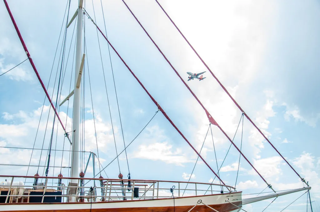 Airplane flying over a moored yacht - Trogir, Croatia - rossiwrites.com