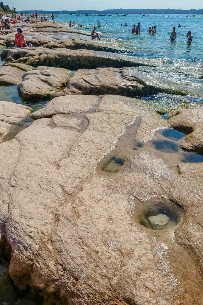 Close-up of the flat rocks of Jamaica Beach - Sirmione, Lake Garda, Italy - rossiwrites.com