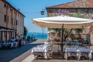 Restaurant with outside tables in the town of Lazise - Lake Garda, Italy - rossiwrites.com