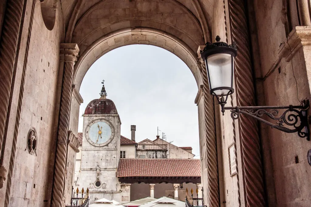 The Clock Tower and the City Loggia seen through the entrance of the Cathedral of St. Lawrence - Trogir, Croatia - rossiwrites.com