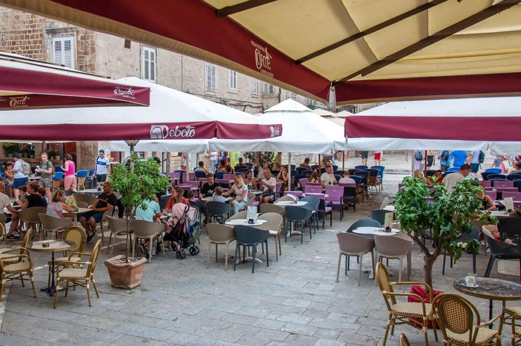 The outside tables of a cafe at the main square - Trogir, Croatia - rossiwrites.com
