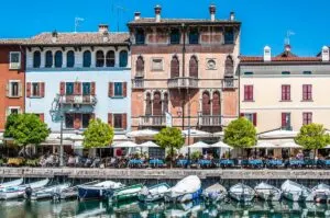 The tables of the local restaurants line up the historic harbour - Desenzano del Garda, Italy - rossiwrites.com