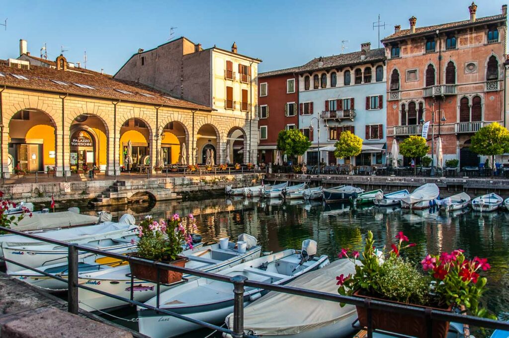 View of the historic harbour of Desenzano del Garda with boats and beautiful houses - Lake Garda, Italy - rossiwrites.com