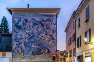 A large mural depicting Lake Como on the side of a building in the town of Cernobbio - Lake Como, Italy - rossiwrites.com
